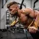 topless man in black pants holding black and yellow exercise equipment